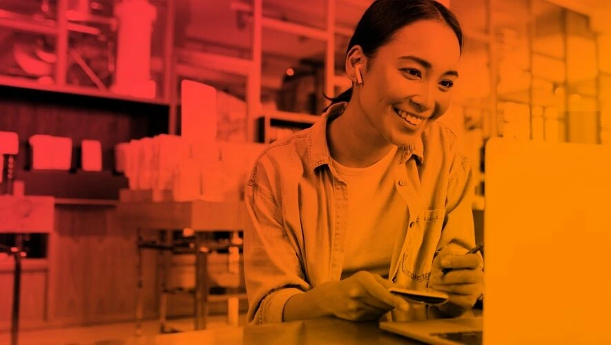 Frau lacht in Laptop, Hybride Arbeitskultur - Interne Kommunikation