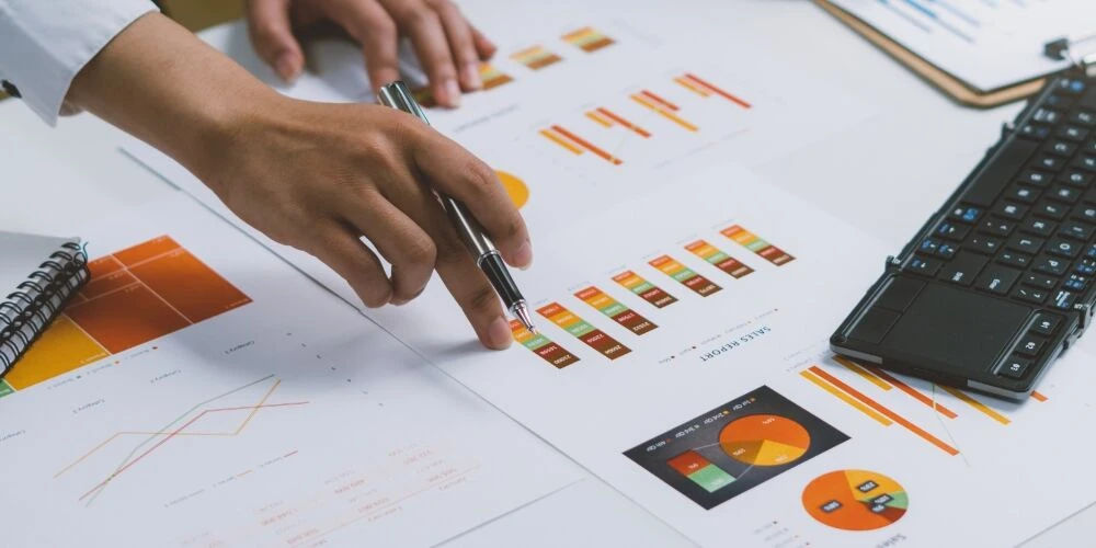 Hand, die auf Auswertungen von Strategiekommunikation zeigt